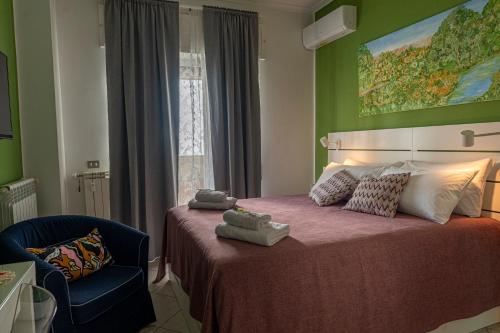 那不勒斯Renza House Chiaia的一间卧室配有一张床、一把椅子和一幅画