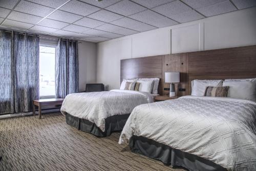 卡普斯卡辛Apollo Motel的酒店客房设有两张床和窗户。