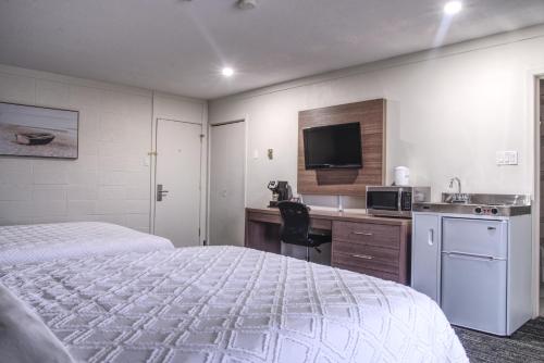 卡普斯卡辛Apollo Motel的酒店客房配有一张床和一张带微波炉的书桌