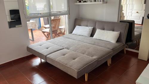 萨贡托PLAYA ALMARDA CORINTO, PISCINA, WIFI,2 TERRAZAS, BARBACOA,TRANQUILo的客厅里配有一张带两个枕头的沙发