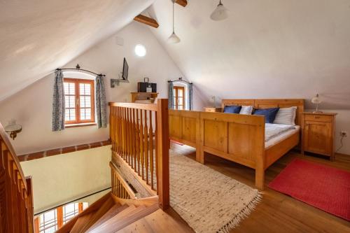 哈特贝格Landlust-Ferienhaus Am Rosenhof的一间卧室配有一张床,房间设有楼梯