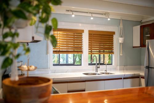 BethanyCruz Bay Tropical Condo的带水槽的厨房和带百叶窗的窗户