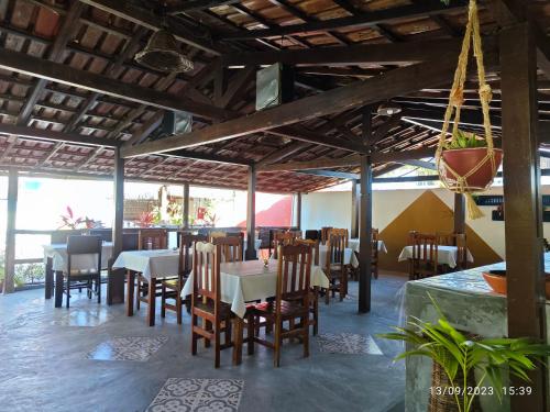 伊列乌斯Pousada Villa Graciela的餐厅内带桌椅的用餐室