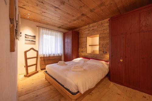 科尔蒂纳丹佩佐Casa Alvera Dream的木制客房内的一间卧室,配有一张床