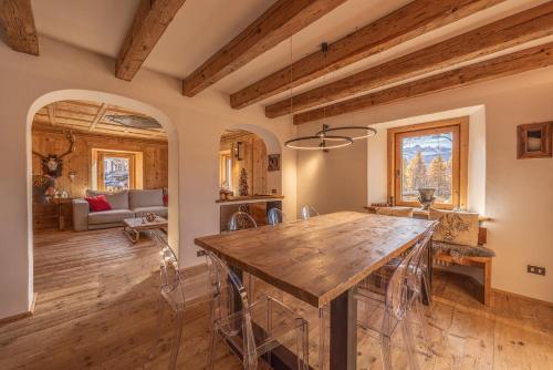 科尔蒂纳丹佩佐Casa Alvera Dream的厨房以及带木桌的起居室。