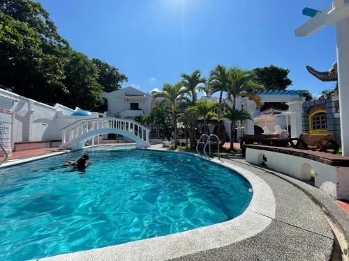 圣胡安Villa Apolonia Resort的在一座带桥梁的游泳池游泳的人