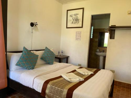 圣胡安Villa Apolonia Resort的一间卧室配有一张带蓝色枕头和水槽的床
