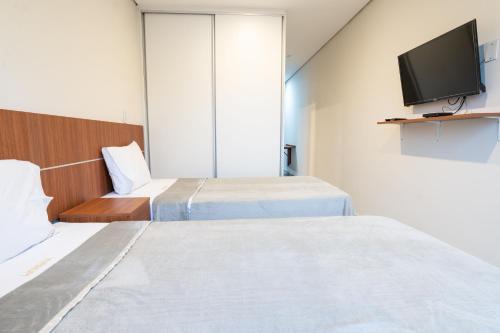 亚松森VIVARIUM APART HOTEL的酒店客房设有两张床和一台平面电视。