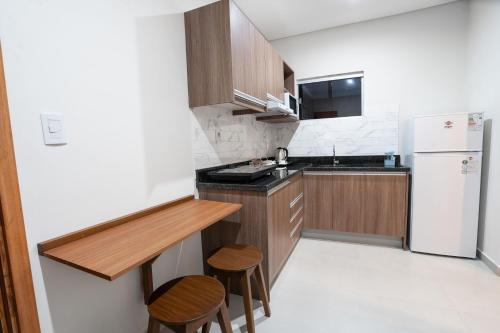 亚松森VIVARIUM APART HOTEL的厨房配有白色冰箱和木制橱柜。