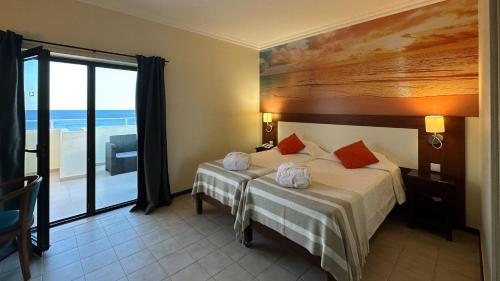 波尔蒂芒普拉亚大道酒店的一间卧室设有一张床,享有海景
