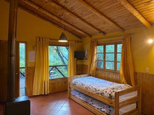 圣何塞德迈波Cabañas Parque Almendro的一间卧室设有一张床和一个大窗户