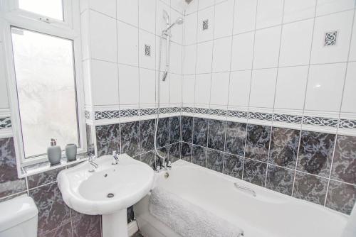 BentleyK Suites - Arthur Street Doncaster的一间带水槽、浴缸和卫生间的浴室