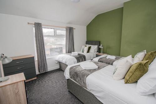 BentleyK Suites - Arthur Street Doncaster的一间卧室设有两张床和窗户。