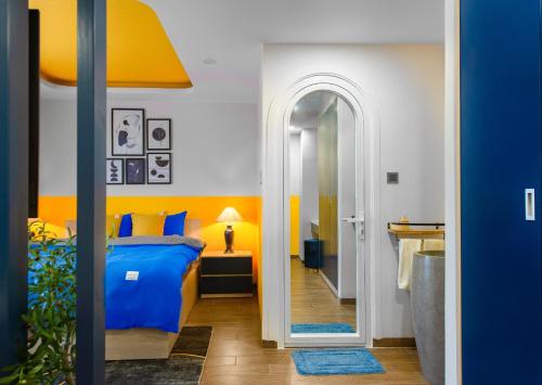 芽庄Pavillon Garden Hotel & Spa Nha Trang的一间卧室设有蓝色的床和黄色的墙壁