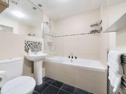 泰晤士河畔沃尔顿Pass the Keys Cosy 2BR Home in Walton的白色的浴室设有卫生间、浴缸和水槽。