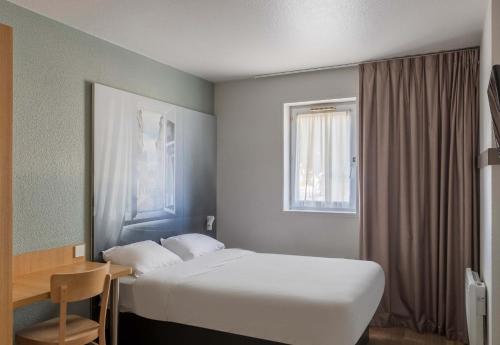 布尔日B&B HOTEL Bourges 1的酒店客房设有床和窗户。