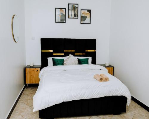 达累斯萨拉姆LM Apartments的一间卧室配有一张大床和黑色床头板
