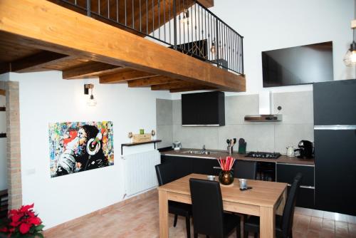 帕武洛内尔夫里尼亚诺B & B CA’ D’ OLINA的厨房以及带木桌的用餐室。
