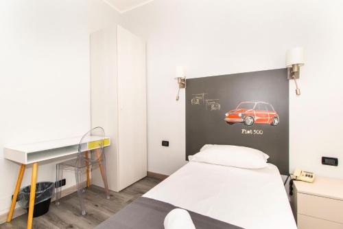 都灵克丽斯塔罗都灵诺酒店的卧室配有一张床铺,墙上挂有汽车