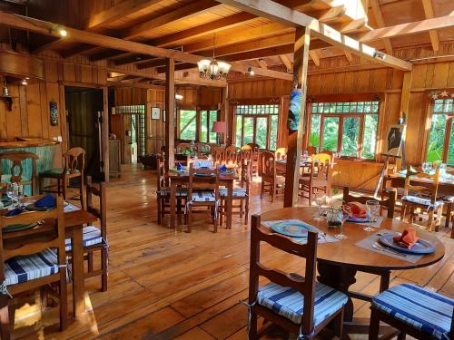 明多Mindo Garden Lodge and Wildlife Reserve的用餐室配有木桌和椅子