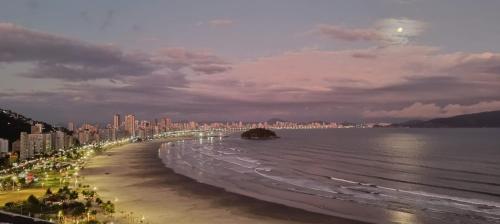 圣维森特岛Vista Mar Espaçoso Praia de Itararé的享有海滩的夜间美景,设有建筑