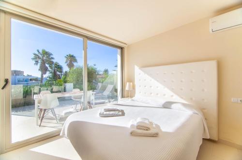 萨阿拉德洛斯阿图内斯Playa Blanca Zahara的卧室设有白色的床和大窗户