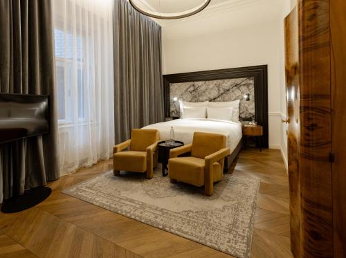 布达佩斯Hotel Collect - Adults Only的酒店客房,配有一张床和两把椅子