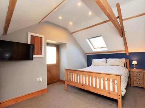 Llandybie2 bed property in Ammanford 87025的一间卧室配有一张床和一台平面电视