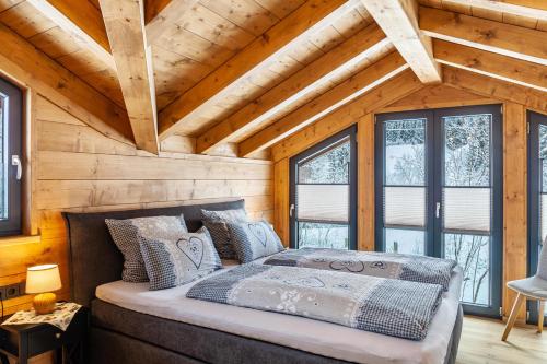 加尔米施-帕滕基兴Chalet Aus Holz的木墙和窗户的客房内的一张床位