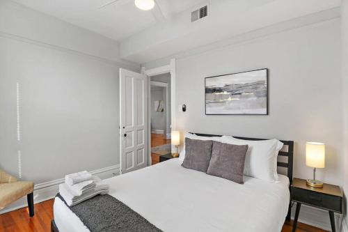 芝加哥2BR Bright and Lovely Apt - Leland 3的白色卧室配有床和椅子