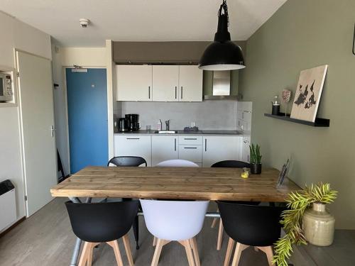 霍勒姆Appartement Senang, Resort Amelander Kaap的厨房配有木桌和椅子