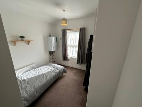 唐克斯特Modern 3BD Home Doncaster South Yorkshire的一间卧室设有一张床和一个窗口