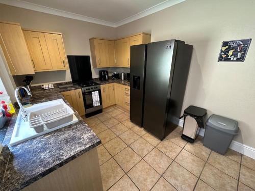 唐克斯特Modern 3BD Home Doncaster South Yorkshire的厨房配有黑色冰箱和垃圾桶