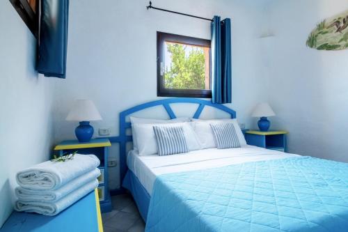 巴哈撒丁岛Residence I Cormorani Bis的蓝色的卧室设有蓝色的床和窗户
