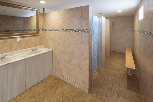 圣奥古斯丁Ocean Grove RV Resort St Augustine的带淋浴、盥洗盆和镜子的浴室
