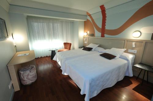 布尔戈斯Hotel Corona de Castilla Burgos的酒店客房设有一张白色大床和一个窗户。