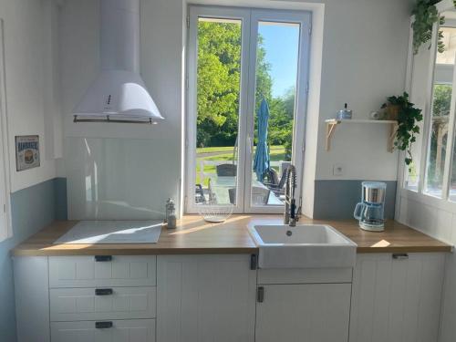 SenlisseLe cottage des Vaux的白色的厨房设有水槽和窗户