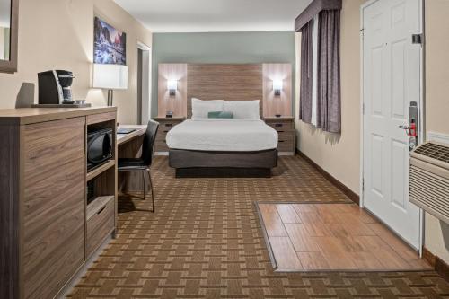 格罗夫兰巴克牧场山林小屋的配有一张床和一张书桌的酒店客房