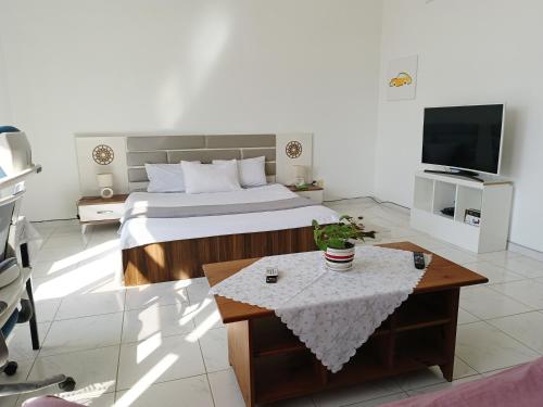 迪拜Jumeirah Beach Villa的一间卧室配有一张床、一张桌子和一台电视。