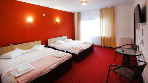 布朗Pensiunea Montan din Bran,sat Simon SPA indoor的酒店客房设有两张床和一张桌子。