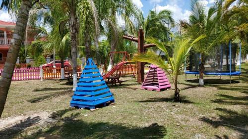 科尔特斯港Casa en la playa puerto cortes的一个带三个棕榈树游乐场的公园