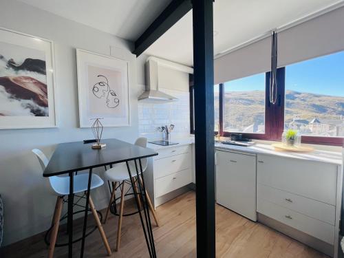 塞拉内华达Apartamentos Sierra Nevada BlueTTravel - Zona baja的厨房配有桌椅和窗户。