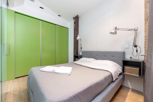 格拉纳达LA CATOLICA GUEST HOUSE的一间卧室配有一张带绿色橱柜的大床