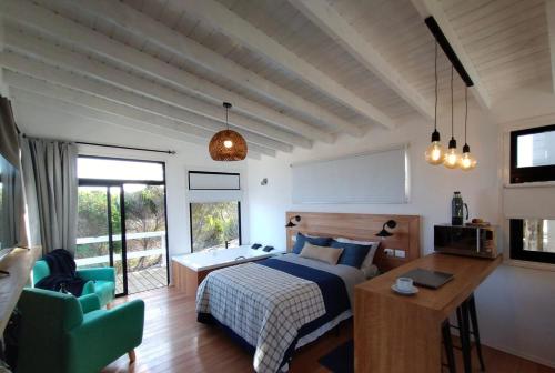 德尔迪阿布罗角Las Rochas, Suites de Mar的一间卧室配有一张床、一张桌子和一把椅子