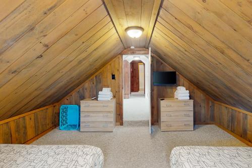 MontgomeryJay Peak Getaway on Trout River的阁楼卧室配有两张床和电视