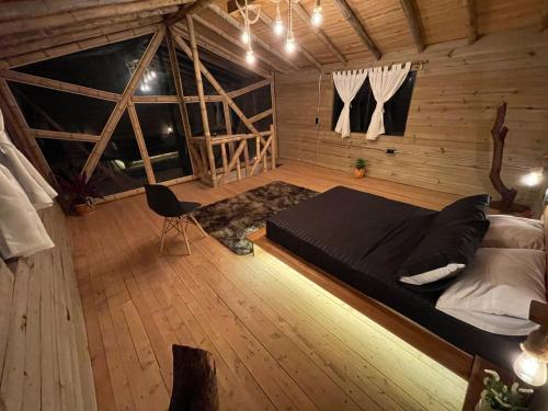 麦德林Bamboo Lodge, vista privilegiada a las montañas的木制客房内的一间卧室配有一张大床