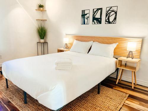 圣地亚哥Sunkissed Boho Hilltop Haven Apartment的卧室配有一张白色大床和木制床头板