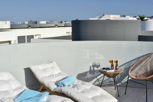 拉奥利瓦Luxury aparment in casilla de costa with Jacuzzi- Follow the sun的大楼内的阳台配有两把椅子和一张桌子