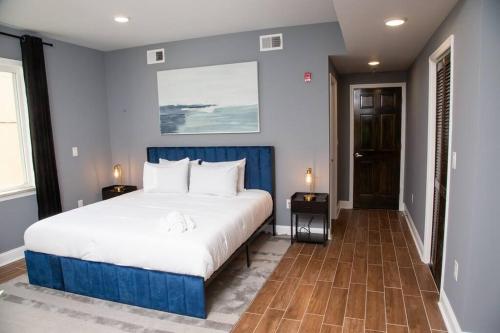 费城Lux Stay by Center City/Temple的卧室配有白色大床和蓝色的墙壁