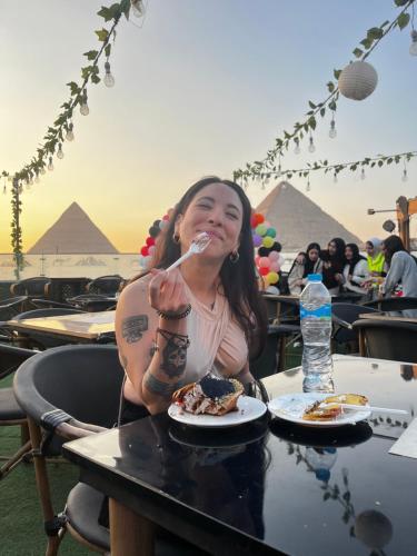 开罗Sahure Pyramid View lnn的坐在餐桌上吃食物的女人